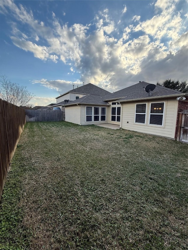 back of house featuring a patio and a lawn