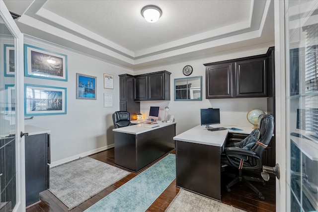 office area with hardwood / wood-style floors, a raised ceiling, and a textured ceiling