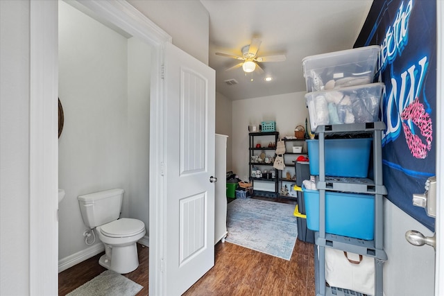 bathroom with hardwood / wood-style flooring, ceiling fan, and toilet