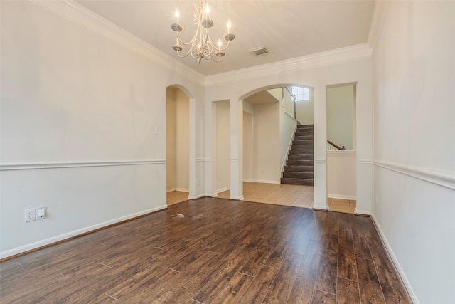 spare room with hardwood / wood-style floors, crown molding, and a chandelier