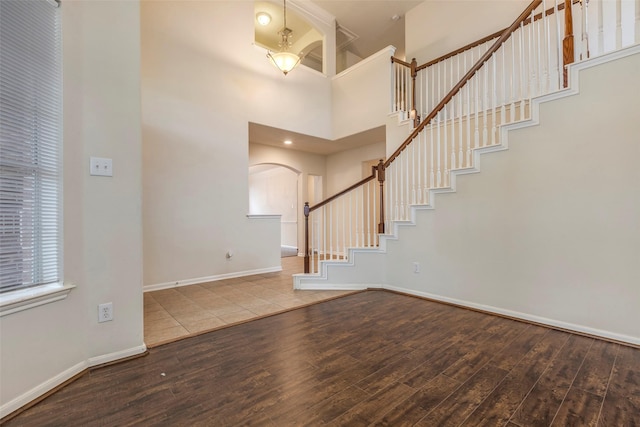 foyer entrance featuring a towering ceiling and hardwood / wood-style floors