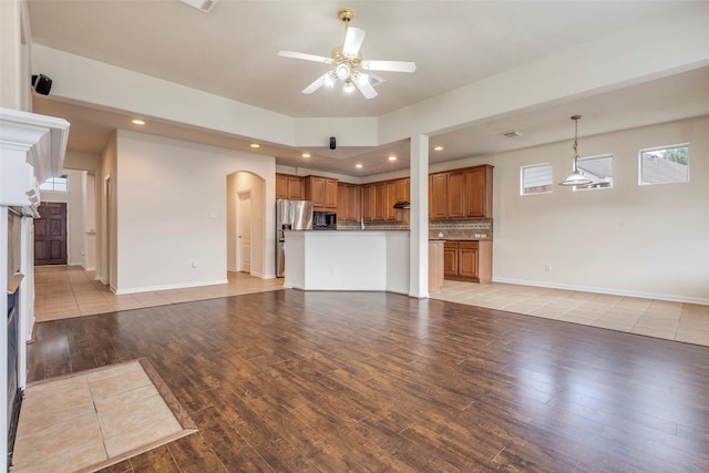 unfurnished living room with ceiling fan and light wood-type flooring