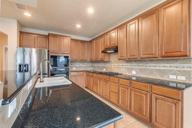 kitchen featuring stainless steel appliances, tasteful backsplash, sink, and dark stone countertops