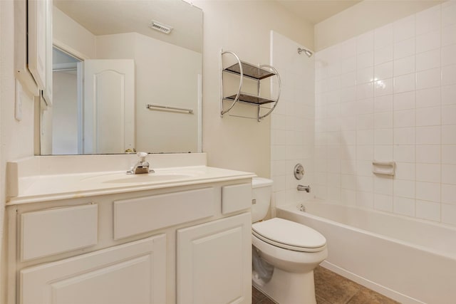 full bathroom with vanity, tiled shower / bath, tile patterned floors, and toilet