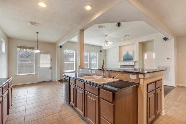 kitchen featuring a kitchen island with sink, sink, a wealth of natural light, and stainless steel dishwasher