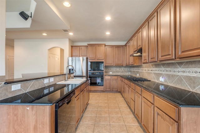 kitchen with sink, decorative backsplash, dark stone counters, light tile patterned floors, and black appliances