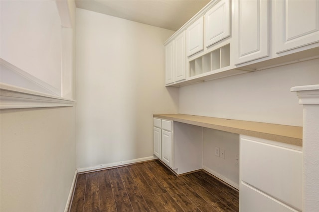 interior space with dark hardwood / wood-style flooring and built in desk