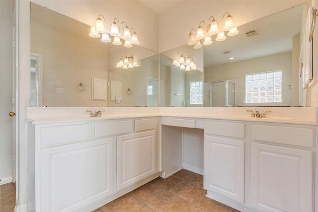 bathroom with a shower with door, vanity, and tile patterned flooring