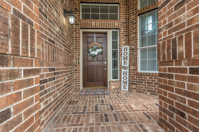 property entrance featuring brick siding