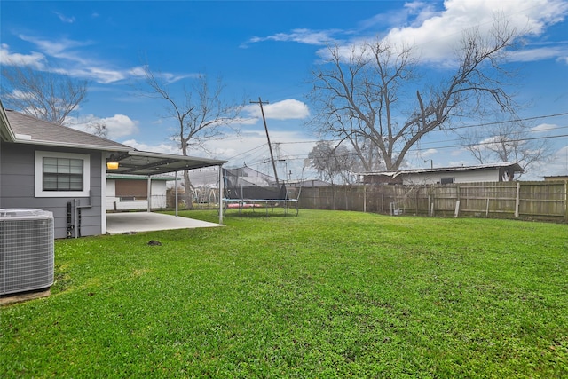 view of yard with central AC, a trampoline, and a patio area