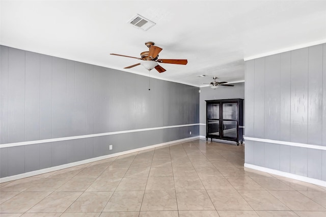 tiled empty room featuring ceiling fan