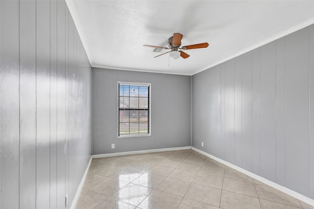 empty room featuring light tile patterned floors, ornamental molding, and ceiling fan