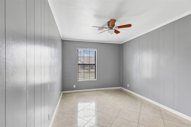 tiled empty room with ornamental molding and ceiling fan