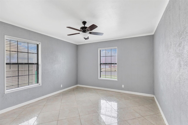 spare room featuring light tile patterned floors, crown molding, and ceiling fan