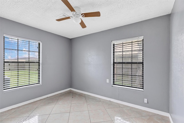 empty room featuring light tile patterned flooring, ceiling fan, and a textured ceiling