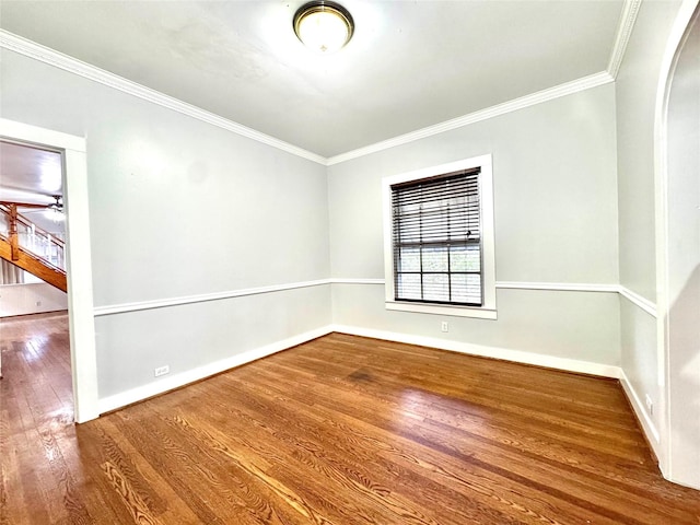 empty room featuring hardwood / wood-style flooring and crown molding