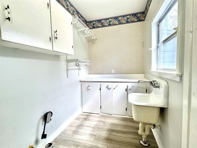 clothes washing area with light hardwood / wood-style floors