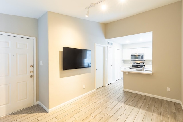 unfurnished living room with track lighting and sink