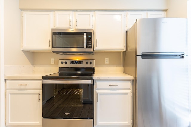 kitchen with white cabinets and appliances with stainless steel finishes