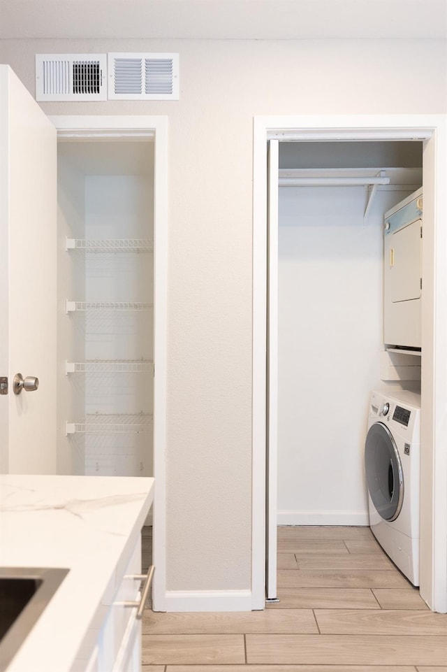 laundry area featuring stacked washer and dryer