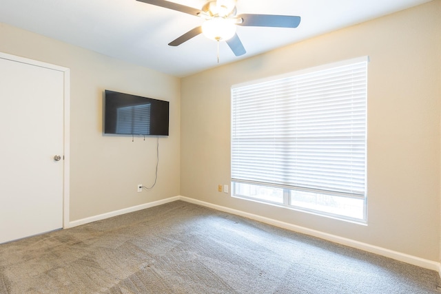 spare room featuring ceiling fan and carpet