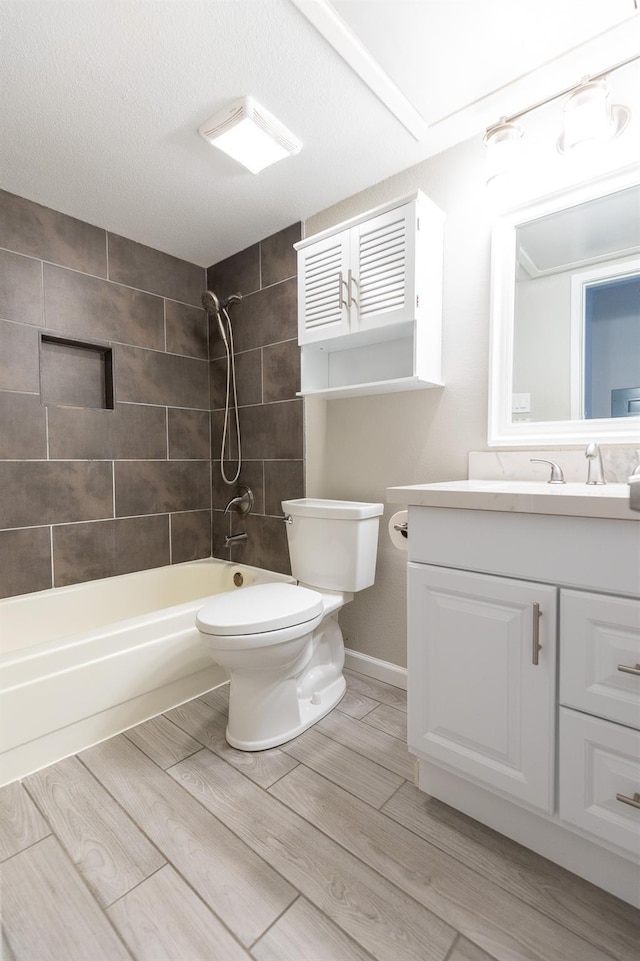 full bathroom with vanity, tiled shower / bath combo, a textured ceiling, and toilet