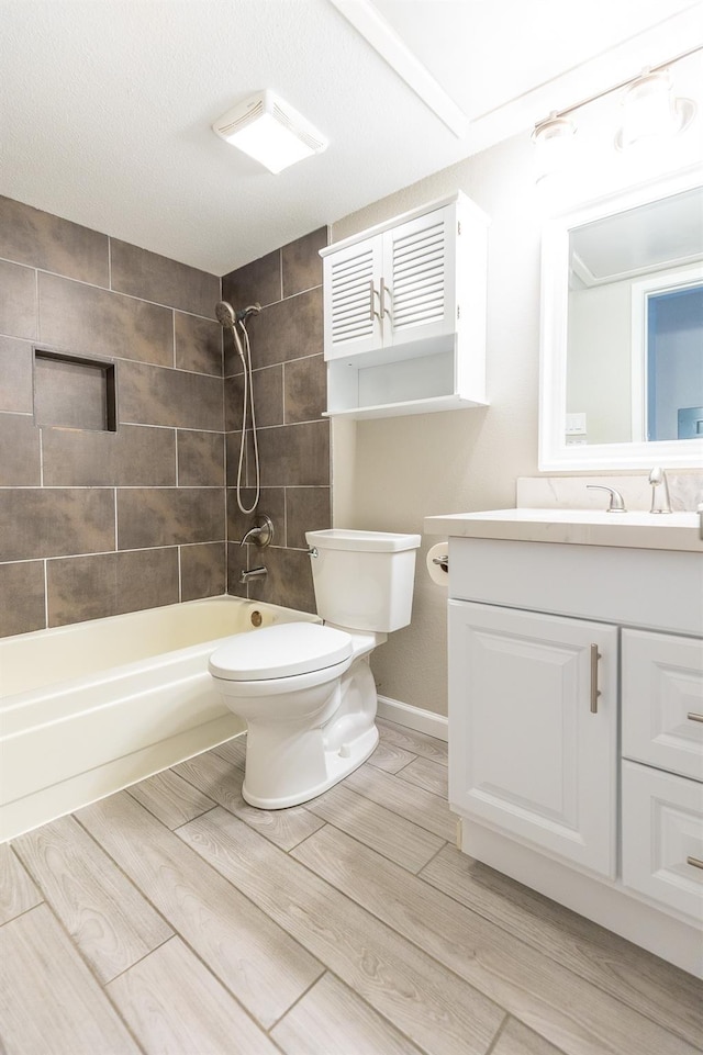 full bathroom featuring vanity, toilet, and tiled shower / bath combo