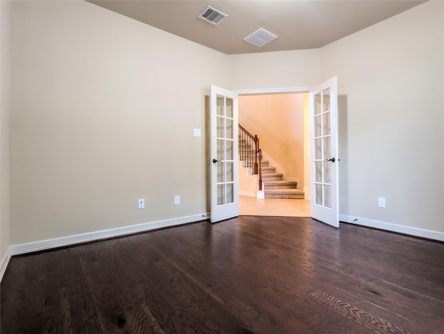 empty room with dark hardwood / wood-style floors and french doors