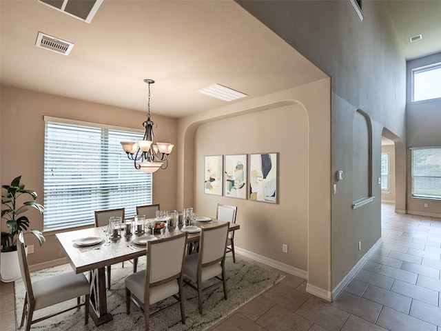 dining area with visible vents, a notable chandelier, baseboards, and tile patterned floors