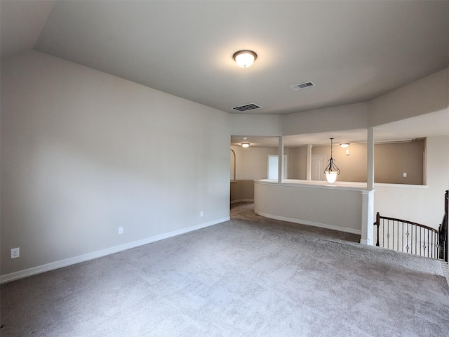 empty room with carpet floors, visible vents, and baseboards