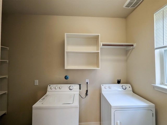 laundry room featuring laundry area, plenty of natural light, washing machine and dryer, and visible vents