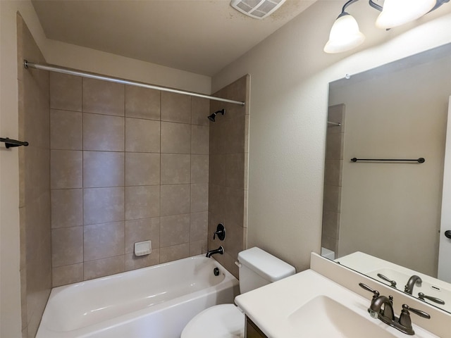 full bathroom with vanity, tiled shower / bath combo, and toilet