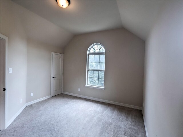 bonus room with lofted ceiling and light carpet