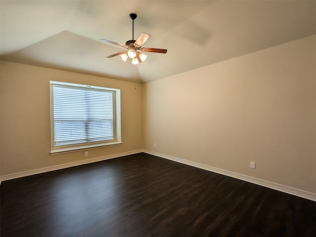 unfurnished room with lofted ceiling, dark wood finished floors, baseboards, and ceiling fan