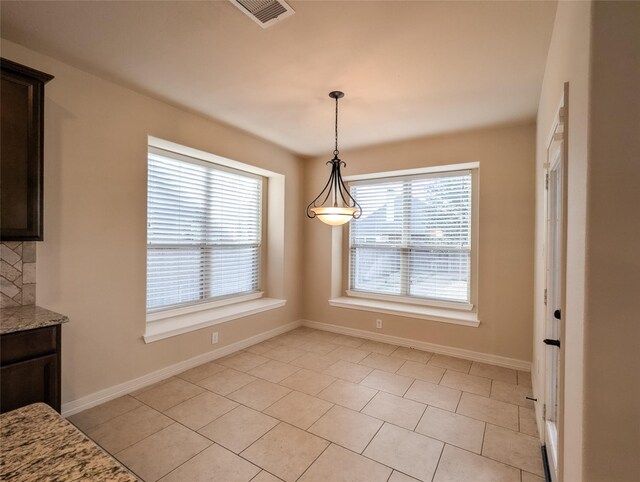 unfurnished dining area with light tile patterned floors and a wealth of natural light