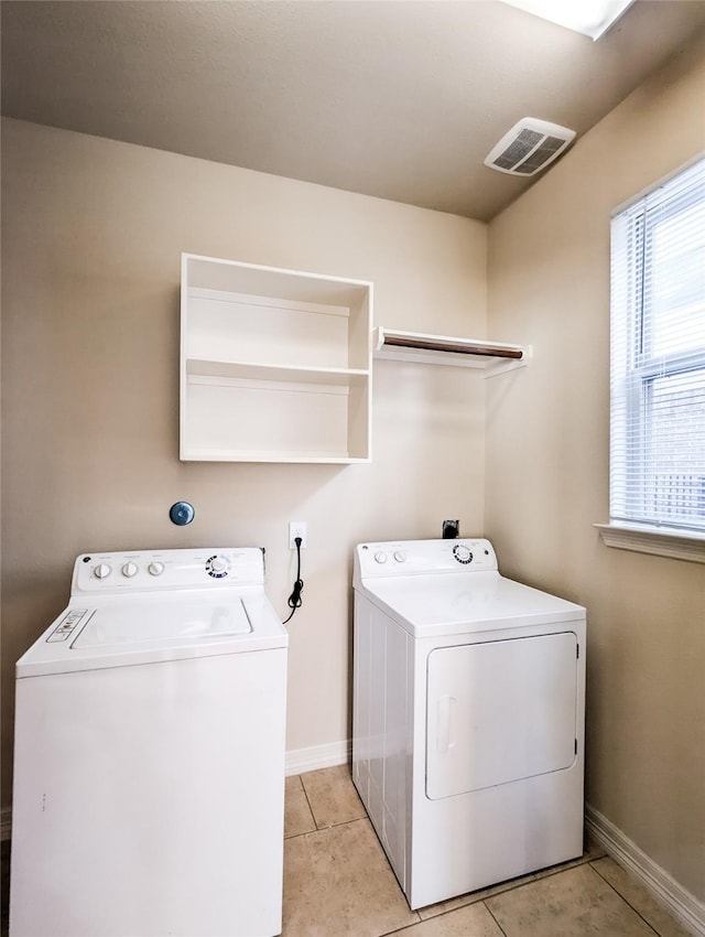 clothes washing area featuring washer and dryer and light tile patterned floors