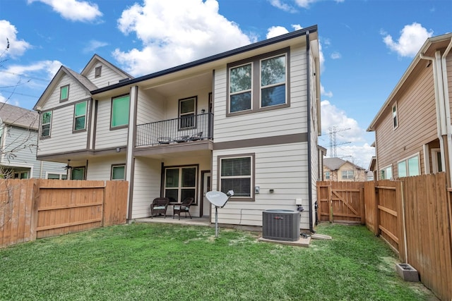 rear view of house with a patio, a balcony, a yard, and central air condition unit