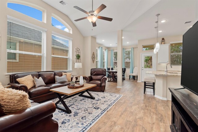 living room with lofted ceiling, sink, ceiling fan, and light wood-type flooring