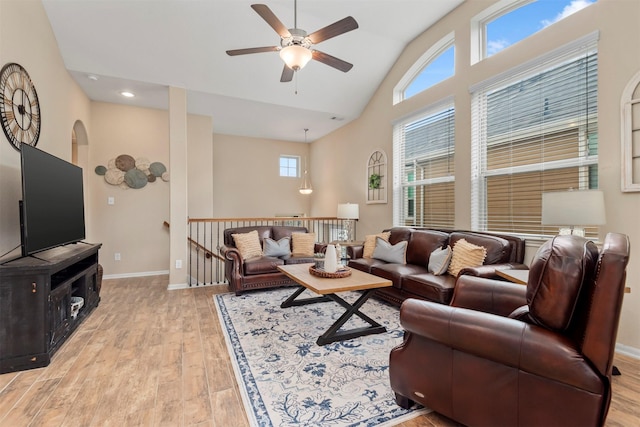 living room featuring high vaulted ceiling, light hardwood / wood-style floors, and ceiling fan