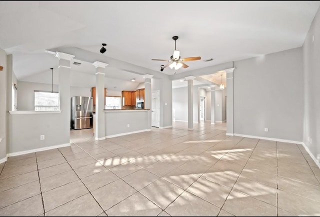 unfurnished living room with vaulted ceiling, decorative columns, ceiling fan, and light tile patterned flooring