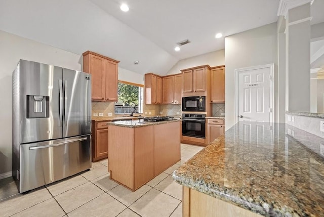 kitchen with vaulted ceiling, tasteful backsplash, a center island, black appliances, and light stone countertops