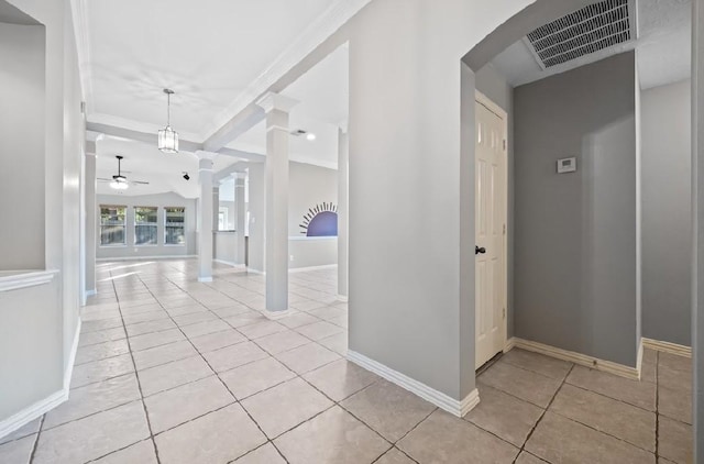 hall featuring crown molding, decorative columns, and light tile patterned floors