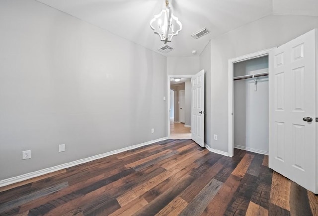 unfurnished bedroom with dark hardwood / wood-style flooring, a closet, and a notable chandelier