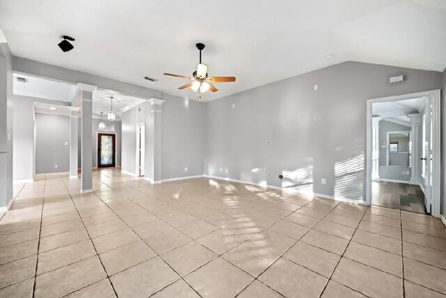 tiled empty room featuring ornate columns, vaulted ceiling, and ceiling fan