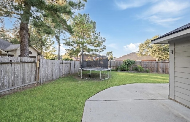 view of yard featuring a trampoline and a patio area