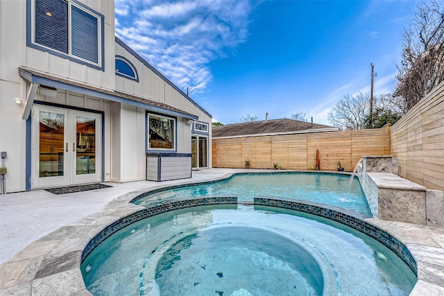 view of pool featuring a pool with connected hot tub, french doors, and fence