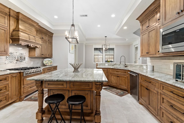 kitchen featuring a breakfast bar, sink, custom exhaust hood, hanging light fixtures, and stainless steel appliances