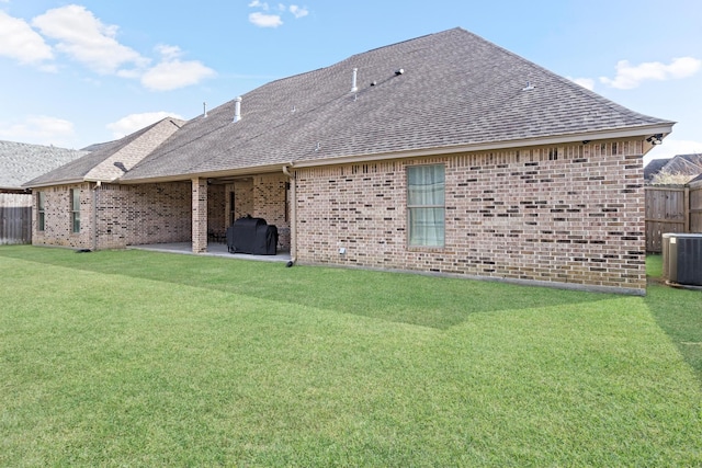 back of house featuring a yard, central AC unit, and a patio