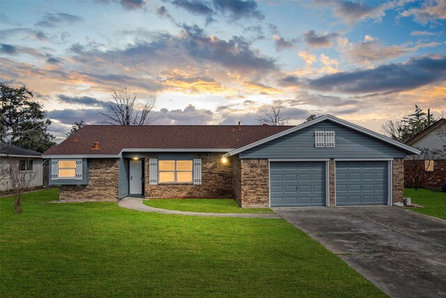 single story home featuring a garage and a yard