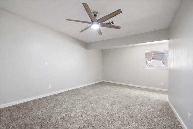 carpeted spare room with a ceiling fan, visible vents, and baseboards